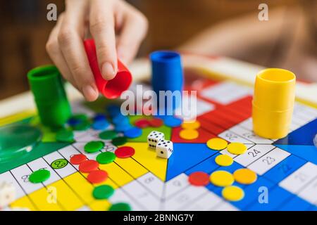 Woman Hand throwing two dices playing Parcheesi, Parchis game board Stock Photo