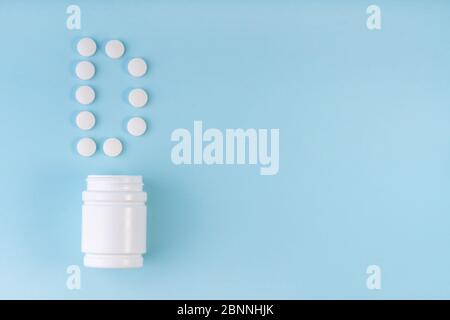 Vitamin D pills dropped from bottle on blue. Letter D inscription from tablets. Vitamin D concept. Immunity protection concept, antiviral prevention. Stock Photo