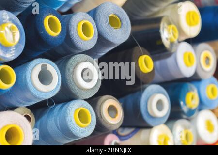 Colored thread on bobbins in a sewing workshop. Garment industry concept Stock Photo