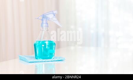 Cleaning product. Spray bottle with light blue liquid on a white table with copy space. Generic cleaning stuff. Isolated cleaning products. Photo with Stock Photo