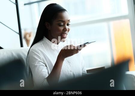 Black Woman Using Mobile Phone For Voice Mail Stock Photo