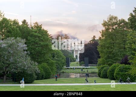 Milan, Italy - May 4, 2020: people exercising, bicycling, walking outdoor, in central Sempione park wearing face mask. On May 4th Italy eases coronavi Stock Photo