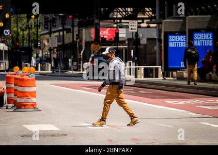 Chicago, USA. 15th May, 2020. A pedestrian wearing a protective mask crosses State Street on Friday May 15, 2020 in Chicago, IL. (Photo by Christopher Dilts/Sipa USA) Credit: Sipa USA/Alamy Live News Stock Photo