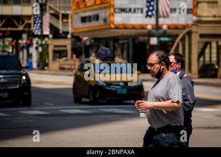 Chicago, USA. 15th May, 2020. Pedestrians, with protective masks pulled down, cross State Street on Friday May 15, 2020 in Chicago, IL. (Photo by Christopher Dilts/Sipa USA) Credit: Sipa USA/Alamy Live News Stock Photo