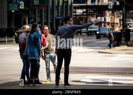 Chicago, USA. 15th May, 2020. Tourists, some wearing protective masks, pose for photos on State Street on Friday May 15, 2020 in Chicago, IL. (Photo by Christopher Dilts/Sipa USA) Credit: Sipa USA/Alamy Live News Stock Photo