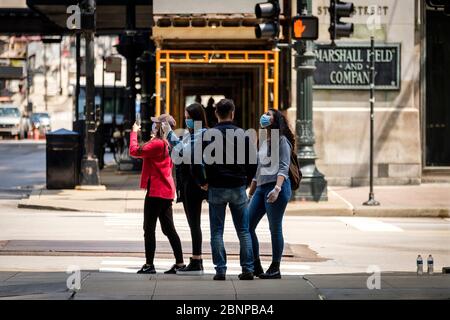 Chicago, USA. 15th May, 2020. Tourists, some wearing protective masks, pose for photos on State Street on Friday May 15, 2020 in Chicago, IL. (Photo by Christopher Dilts/Sipa USA) Credit: Sipa USA/Alamy Live News Stock Photo