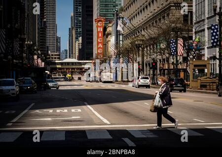 Chicago, USA. 15th May, 2020. A pedestrian wearing a protective face mask crosses State Street on Friday May 15, 2020 in Chicago, IL. (Photo by Christopher Dilts/Sipa USA) Credit: Sipa USA/Alamy Live News Stock Photo
