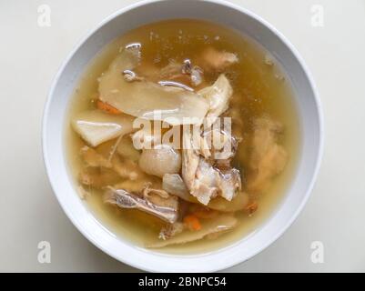 Chinese traditional american ginseng soup with chicken bones served in a bowl. Top view. Stock Photo