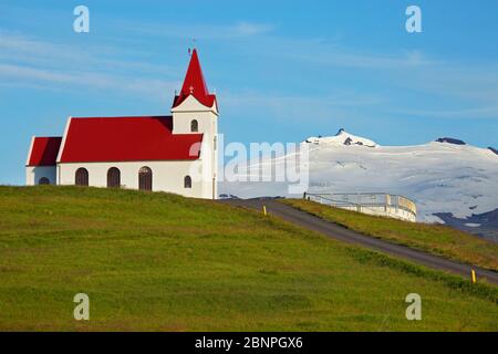 The Ingjaldshoelskirkja near Rif on the Icelandic Snaefellsnes peninsula was built in 1903 and is considered the oldest concrete church in the world and one-year residence of Christopher Columbus. Behind it is the Snaefelsdsjoekull. Stock Photo