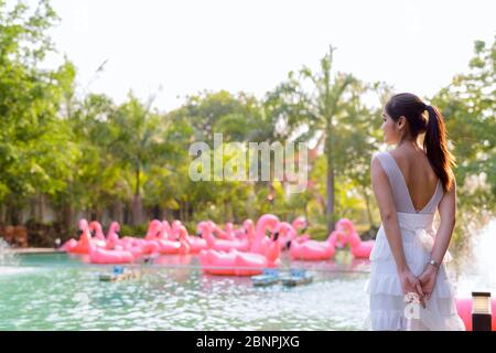 Rear view of young beautiful Asian woman relaxing outdoors Stock Photo