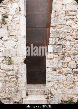 Detail of a modern door embedded in a medieval wall located in the old center of Girona in Catalonia Spain Stock Photo