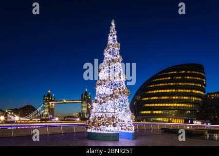 England, London, Southwark, City Hall and Tower Bridge at Night with Eletronic Christmas Tree in Foreground Stock Photo