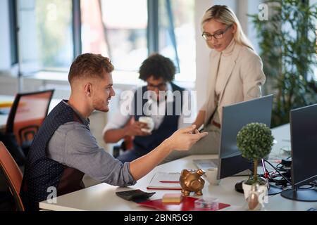 Three young businesspeople in the office on a break Stock Photo