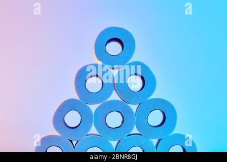 Roll of toilet papers stacked under colorful blue and pink lights. Stock Photo