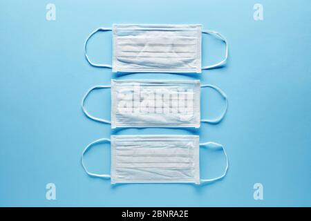 Medical or surgical masks for protection against virus diseases on blue background. COVID-19 or corona virus protection. Stock Photo