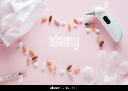 Medical mask, syringe, pills, glove and thermometer on pink background. with copy space Medical  disease treatment concept. Top view. Stock Photo