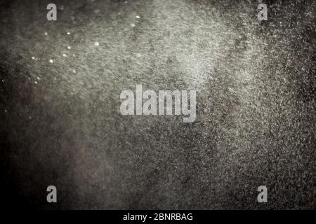 water spray from bottle. close up of a spraying water drops isolated on black background. Stock Photo