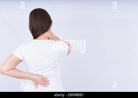 Female touching acute neck and lower back pain on white background with copy space. Medical, healthcare for advertising concept. Stock Photo