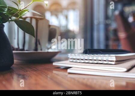 Notebooks, pen and coffee cup on wooden table Stock Photo