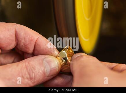 Jewelry production. Jeweler polishes a gold ring on a sander in a jewelry workshop. Stock Photo