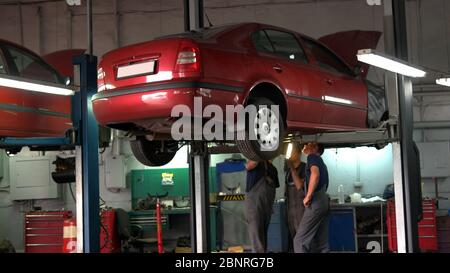 Lifting car at an auto shop by mechanic. Stock Photo