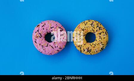 Two fashion round donuts on blue color. colorful minimalism concept. Stock Photo