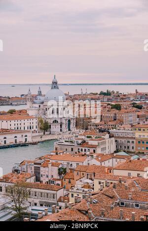 Aerial view from huge cathedral bell tower St Mark's Campanile on Santa Maria - Della - Salute - Church in the name of St. Mary the Savior, sunset sky Stock Photo