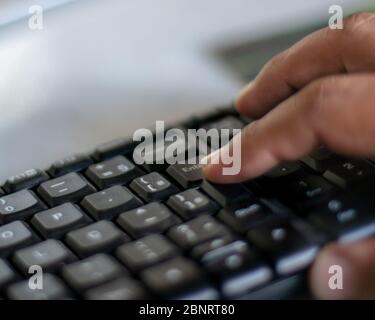 Finger on the enter key - hand pressing "enter" button on computer Stock Photo