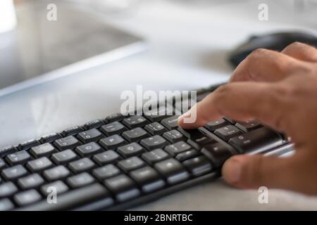 Finger on the enter key - hand pressing "enter" button on computer Stock Photo