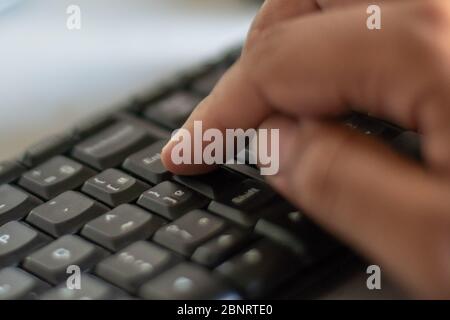 Finger on the enter key - hand pressing "enter" button on computer Stock Photo