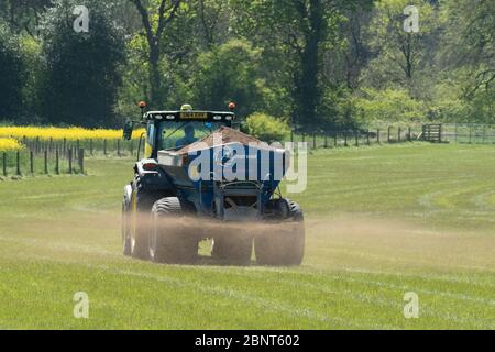 Tractor and lime spreader working in a field in West Lothian, Scotland. Stock Photo