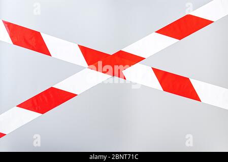 Red white signal striped interdictory tape. Striped line isolated on gray background. Plastic warning tape. Stock Photo
