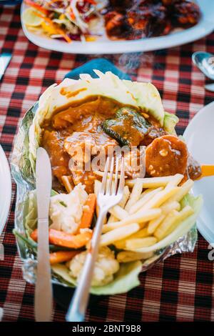 Goa, India. Dish Of Indian National Cuisine Is Sizzler, Which Consist Of French Fries, Fried Shrimp In Sauce, Fried Vegetables. Traditional Dish Of Go Stock Photo