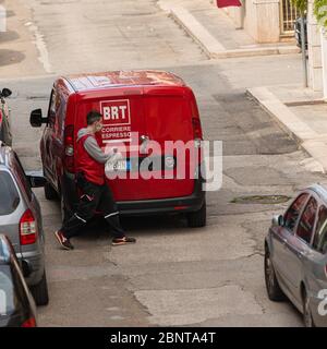 Young courier wearing the mask during coronavirus covid-19 infection near delivery van with parcels. Service quarantine pandemic coronavirus virus 201 Stock Photo