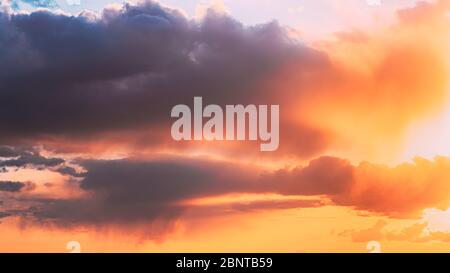 Rain Through Cloudy Sky With Fluffy Clouds During Sunset Sky. Stock Photo
