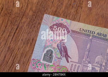 The Currency of the United Arab Emirates (UAE) - Close up of a purple five hundred Dirham note  on a brown table background. Money exchange. Stock Photo