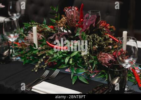 Served restaurant table. Red pepper decoration on a black tablecloth Stock Photo