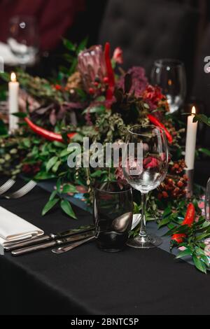 Served restaurant table. Red pepper decoration on a black tablecloth Stock Photo