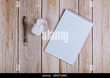 Flat lay of workspace office desk with notebooks, wireless headphones and pen Stock Photo