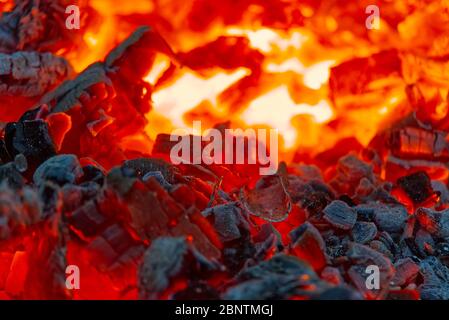 red hot coals in a blast furnace for metal melting. metal mining and processing industry. Red coals from a burnt fire made of wood. Stock Photo