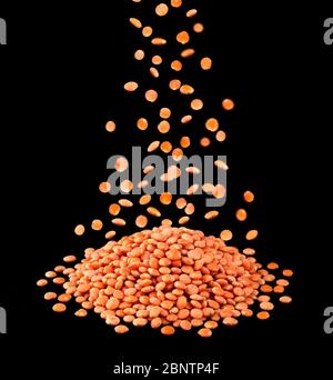 Heap of red lentils isolated on black background Stock Photo