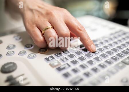 Close up shot of technician operating an ultrasound machine at a clinic. Stock Photo