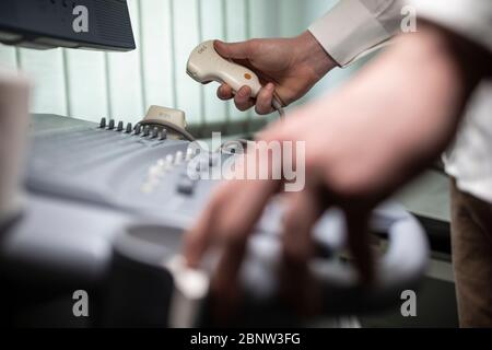 Close up shot of technician operating an ultrasound machine at a clinic. Stock Photo