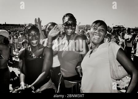 Smiling, happy & waving at the camera Afro-Caribbean teenage girls at a beach concert, Great Yarmouth, Norfolk, England, UK