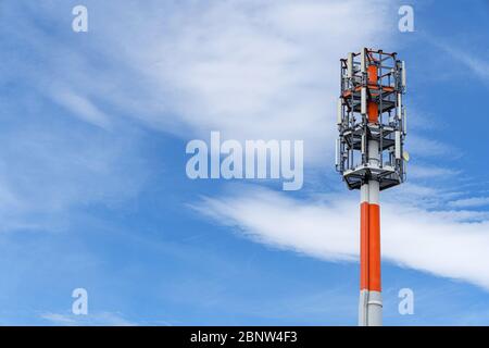 Transmission mast against the blue and white sky Stock Photo