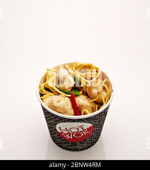 Shot of noodles with pork and vegetables in take-out box on white background Stock Photo