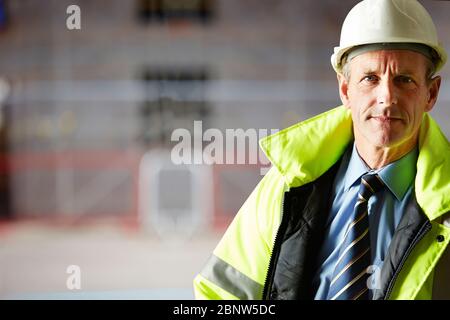 Portrait of confident mature architect wearing a hardhat on construction site Stock Photo