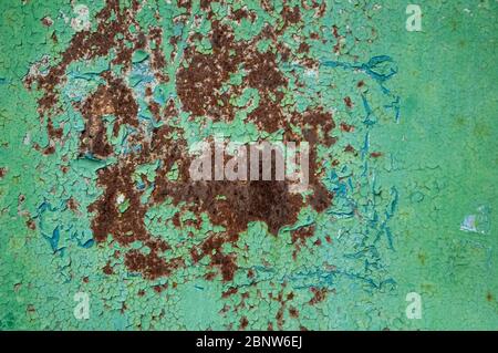 Metal plate, painted with green paint, from which you can see the rust close up. Texture, background Stock Photo