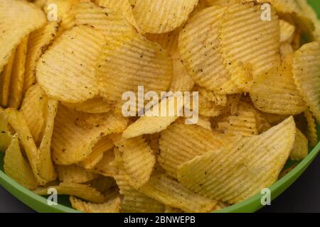 crispy potato chips in a green cup close-up. fried crispy chips Stock Photo