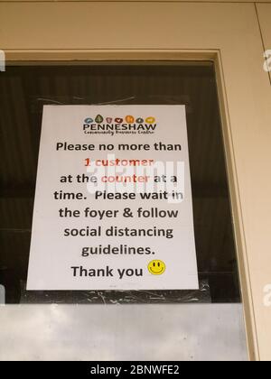 Notice on a window advising people to maintain social distancing during the Coronavirus epidemic. Stock Photo